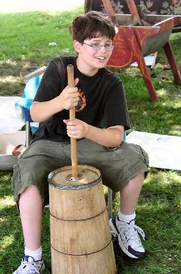 Photo of a young man churning butter.